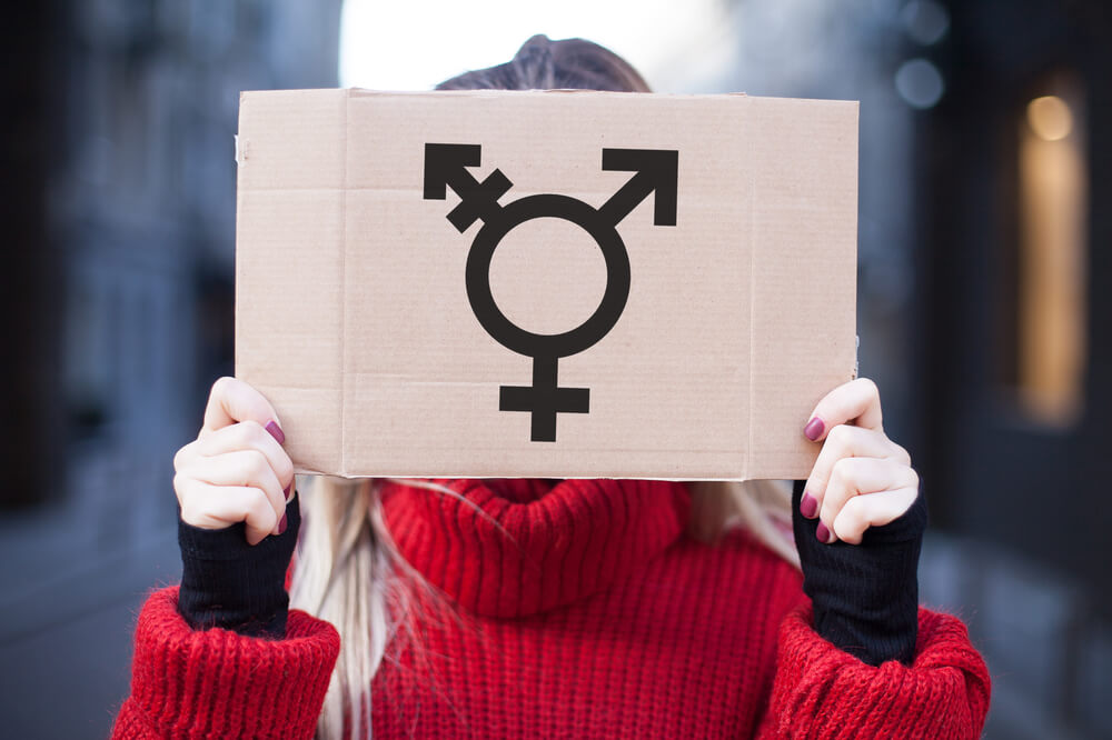 Woman in red holding a three genders' sign